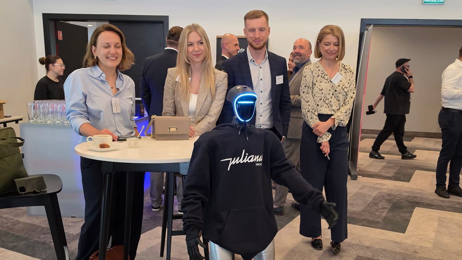 Goście eventu firmowego pozują z robotem humanoidalnym