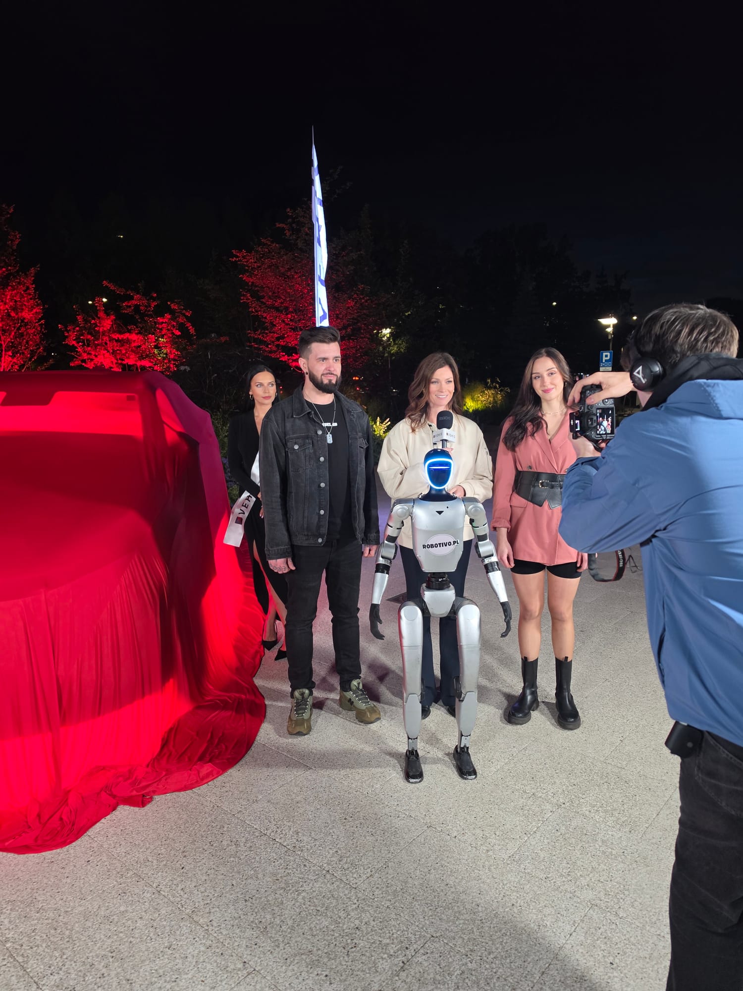 Goście wieczornego eventu pozują z robotem