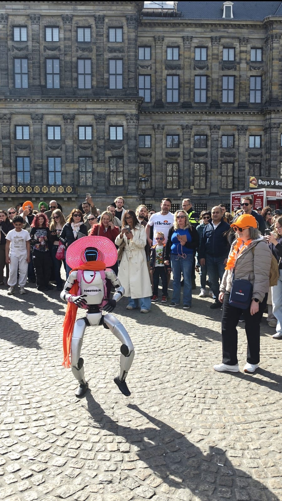 Robot humanoidalny otoczony tłumem podczas pokazu na ulicy